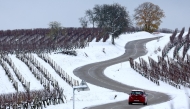 A car runs through the vineyards covered by snow near Andlau, eastern France, on November 22, 2024. Photo by FREDERICK FLORIN / AFP.