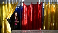 A woman leaves the polling booth prior to vote for the presidential elections at a polling station in Bucharest on November 24, 2024. Photo by Daniel MIHAILESCU / AFP.