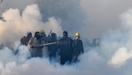 Policemen fire tear gas shells to disperse supporters of Pakistan Tehreek-e-Insaf (PTI) party during a protest to demand the release of former prime minister Imran Khan, in Islamabad on November 26, 2024. (Photo by Aamir Qureshi / AFP)