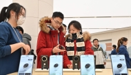 People check Huawei's new Mate 70 mobile phone inside a shop at the Wangfujing shopping area in Beijing on November 26, 2024. (Photo by ADEK BERRY / AFP)
