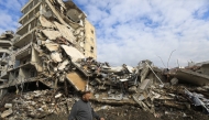 This picture taken a day after a ceasefire between Israel and Hezbollah shows a man walking past destroyed buildings in the southern Lebanese city of Nabatieh on November 28, 2024. Photo by AFP.