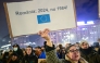 People protest in the front of the Palace of the Parliament at the Victory square in Bucharest, Romania, on November 27, 2024, with a banner reading 