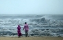 People stand ashore as they observe waves amidst heavy winds and rainfall at Marina Beach in Chennai on November 30, 2024, ahead of the landfall of cyclone Fengal in India's state of Tamil Nadu. (Photo by R. Satish BABU / AFP)
