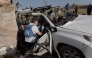 File photo used for representational purposes. United Nations staff members inspect the carcass of a car used by US-based aid group World Central Kitchen, that was hit by an Israeli strike the previous day in Deir al-Balah in the central Gaza Strip on April 2, 2024. Photo by AFP.