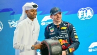 Red Bull Racing’s Dutch driver Max Verstappen (right) receives the pole position trophy from Qatar’s track and field athlete Mutaz Essa Barshim yesterday. AFP