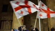 Protesters wave Georgian flags during the fifth straight night of demonstrations against the government's postponement of EU accession talks until 2028, outside the parliament building in central Tbilisi on December 2, 2024. (Photo by Giorgi ARJEVANIDZE / AFP)
