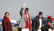 Nepal's prime minister Khadga Prasad Sharma Oli waves alongside his wife Radhika Shakya before his departure, at the Tribhuvan International airport in Kathmandu on December 2, 2024. (Photo by Aryan Dhimal / AFP)