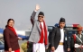 Nepal's prime minister Khadga Prasad Sharma Oli waves alongside his wife Radhika Shakya before his departure, at the Tribhuvan International airport in Kathmandu on December 2, 2024. (Photo by Aryan Dhimal / AFP)