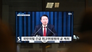 South Korea's President Yoon Suk Yeol is seen speaking on a television in a train station in Seoul late on December 3, 2024, after he declared emergency martial law, saying the step was necessary to protect the country from 