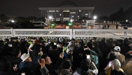 People gather in front of the main gate of the National Assembly in Seoul, South Korea on December 4, 2024, after President Yoon Suk Yeol declared emergency martial law. Photo by JUNG YEON-JE / AFP