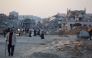 Palestinians walk in a devastated neighbourhood due to Israeli strikes in the southern Gaza Strip's city of Khan Yunis on December 2, 2024. Photo by Bashar TALEB / AFP.