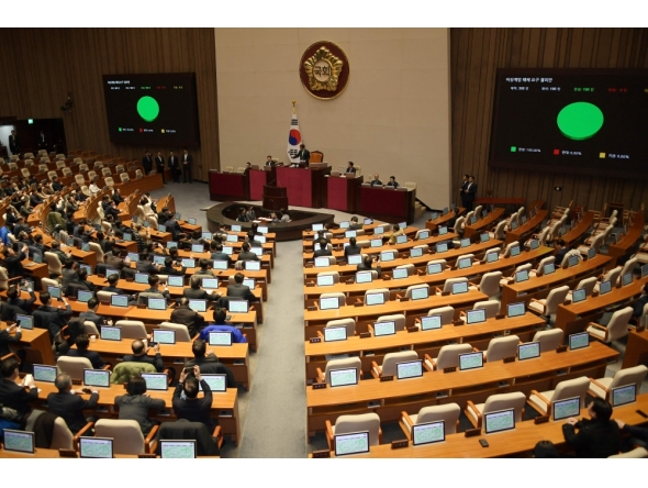 South Korea's National Assembly Speaker Woo Won-shik (Centre top) passes a resolution demanding the immediate lifting of martial law at the National Assembly in Seoul on December 4, 2024, after South Korea President Yoon Suk Yeol declared martial law. (Photo by Yonhap / AFP) 