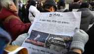 Photo used for representational purposes. A man reads an extra edition newspaper in downtown Seoul on December 4, 2024, after martial law was lifted. Photo by Jung Yeon-je / AFP.