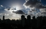 (Files) This file photo taken on September 17, 2024 shows buildings silhouetted as clouds drift past the sun in Shanghai. (Photo by Hector Retamal / AFP)