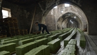 (Files) A Syrian worker stacks laurel soap at the Jbaili soap factory, an 800 year old artisanal soap manufacturer, in the old city of Syria's northern city of Aleppo on January 24, 2022. (Photo by AFP)
 