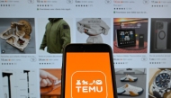 (FILES) This photograph shows the logo of Chinese e-commerce company Temu displayed on a mobile phone in front of a screen showing the company's website in Brussels on November 4, 2024. (Photo by Nicolas TUCAT / AFP)
