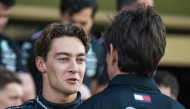 Mercedes' British driver George Russell speaks with Mercedes' Austrian team principal and CEO Toto Wolff as they arrive for a group photo with his team ahead of the Abu Dhabi Formula One Grand Prix at the Yas Marina Circuit in Abu Dhabi on December 5, 2024. (Photo by Andrej ISAKOVIC / AFP)