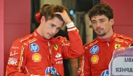 Ferrari's Monegasque driver Charles Leclerc (R) speaks to his brother Ferrari's reserve driver Arthur Leclerc after the first practice session ahead of the Abu Dhabi Formula One Grand Prix at the Yas Marina Circuit in Abud Dhabi on December 6, 2024. Photo by Andrej ISAKOVIC / AFP.