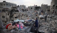 Palestinians inspect the damage after an Israeli strike on the Nuseirat refugee Camp in the central Gaza Strip on December 7, 2024. (Photo by Eyad BABA / AFP)
