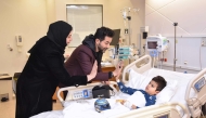 QNB officials with a young patient during the visit.