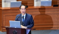 South Korean Prime Minister Han Duck-soo attends a plenary session, where a question-and-answer session was held relating to the martial law declaration, at the National Assembly in Seoul on December 11, 2024. South Korean police raided President Yoon Suk Yeol's office on December 11 as the investigation into his declaration of martial law gathered pace. (Photo by JUNG YEON-JE / AFP)