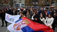 Students, behind a banner reading 