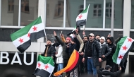 Members of the Syrian community hols flags of Syria and Germany as they rally on December 8, 2024 in Berlin, Germany, to celebrate the end of Syrian dictator Bashar al-Assad's rule after rebel fighters took control of the Syrian capital Damascus overnight. Islamist-led rebels toppled Syria's longtime ruler Bashar al-Assad in a lightning offensive that a UN envoy called 