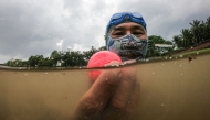 In this picture taken on November 11, 2024, Sumadi Ibrahim shows a golf ball he found inside a pond at a course in Shah Alam, on the outskirts of Kuala Lumpur. (Photo by Mohd Rasfan / AFP)