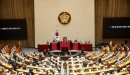 South Korean lawmakers cast their votes during a plenary session for the impeachment vote of President Yoon Suk Yeol at the National Assembly in Seoul on December 14, 2024. (Photo by Woohae Cho / Pool / AFP)