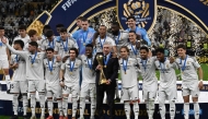 Real Madrid's Italian coach Carlo Ancelotti holds the tournament trophy as he poses with his players for the group picture at the podium ceremony after the 2024 FIFA Intercontinental Cup final football match between Spain's Real Madrid and Mexico's Pachuca at the Lusail Stadium in Doha on December 18, 2024. (Photo by Mahmud Hams / AFP)

