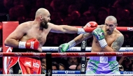 Britain's Tyson Fury (red) and Ukraine's Oleksandr Usyk (blue) compete during their heavyweight world championship rematch at the Kingdom Arena in Riyadh on December 22, 2024. (Photo by AFP)