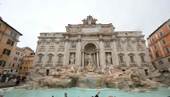 The mayor of Rome, Roberto Gualtieri (4th right) throws a coin in the Trevi fountain on the day of its reopening after renovation works in Rome, on December 22, 2024. (Photo by Alberto Pizzoli / AFP)