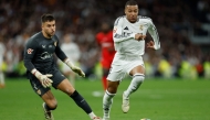 Real Madrid's French forward #09 Kylian Mbappe and Sevilla's Spanish goalkeeper #01 Alvaro Fernandez (left) vie for the ball during the Spanish league football match between Real Madrid CF and Sevilla FC at the Santiago Bernabeu stadium in Madrid on December 22, 2024. (Photo by Oscar Del Pozo / AFP)