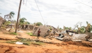 This handout picture taken and distributed by UNICEF on December 15, 2024 shows a child standing next to damaged homes after Cyclone Chido made its landfall in Mecufi district, Cabo Delgado proving, in Mozambique. Photo by Eduardo Mendes / UNICEF / AFP