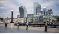 A file photo of people looking out at the skyline of London's financial district.