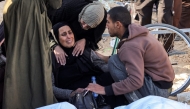 A woman is comforted as she mourns by the body of one of the martyrs killed in overnight Israeli bombardment outside the morgue of Nasser Medical Complex in Khan Yunis in the southern Gaza Strip on December 23, 2024 (Photo by BASHAR TALEB / AFP)
