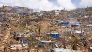 This photograph shows a general view of damaged shelters and houses in the town of Vahibe, on the outskirts of Mamoudzou, on the French Indian Ocean territory of Mayotte, on December 24, 2024, a week after the cyclone Chido's passage over the archipelago. (Photo by PATRICK MEINHARDT / AFP)
