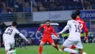 Bahrain's Ali Madan (centre) shoots to score a goal against Iraq.