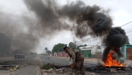 Mozambican security forces are seen next to a burning barricade in Maputo on December 24, 2024. (Photo by Amilton Neves / AFP)
