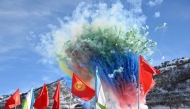 In this handout picture taken and released by the Kyrgyz presidential press office on December 27, 2024, fireworks explode behind state flags during the commencement ceremony of the China-Kyrgyzstan-Uzbekistan railway project in the settlement of Tash-Kitchu. (Photo by Handout / KYRGYZ PRESIDENTIAL PRESS OFFICE / AFP)