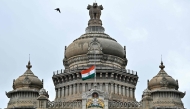 The Indian national flag flies half-mast at the Vidhana Soudha to mourn the death of former Indian Prime Minister Manmohan Singh, in Bengaluru on December 27, 2024. 