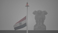 The Indian national flag flies half-mast at the Parliament to mourn the death of former Indian Prime Minister Manmohan Singh, as it rains in New Delhi on December 27, 2024. (Photo by Arun Sankar / AFP)