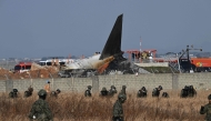 South Korean soldiers search for missing passengers near the wreckage of a Jeju Air Boeing 737-800 series aircraft after the plane crashed and burst into flames at Muan International Airport in South Jeolla Province on December 29, 2024. (Photo by Jung Yeon-Je / AFP)