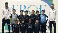 The victorious Msheireb Academy players and officials pose for a photograph.