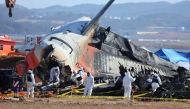 Police forensics personnel and National Bureau of Investigation officials work at the Jeju Air crash site in Muan on December 31, 2024. (Photo by YONHAP / AFP)