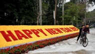 Photo used for representational purposes. Children ride their bicycle past a New Year 2025 numerals decoration made of plastic flowers in Hanoi on December 30, 2024. Photo by Nhac NGUYEN / AFP.
