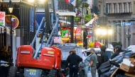 Police investigators surround a white truck that has been crashed into a work lift in the French Quarter of New Orleans, Louisiana, on January 1, 2025. (Photo by Matthew Hinton / AFP)