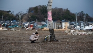 A woman prays near the former tourist spot of 