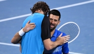 Winner Reilly Opelka of the United States (left) and Serbia's Novak Djokovic embrace at the net after their men's singles quarter-final match at the Brisbane International tennis tournament in Brisbane on January 3, 2025. (Photo by William West / AFP)