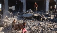 Palestinian children salvage a blanket amid the destruction in the aftermath of an Israeli strike in the al-Maghazi refugee camp in the central Gaza Strip on January 3, 2025. (Photo by Eyad Baba / AFP)
